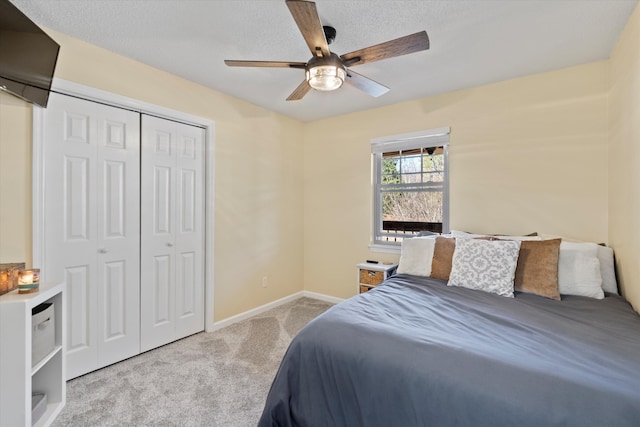 bedroom with light carpet, a textured ceiling, ceiling fan, and a closet