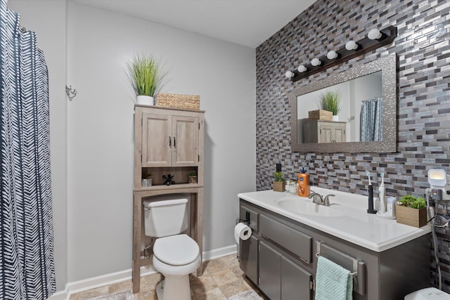 bathroom with toilet, decorative backsplash, and vanity