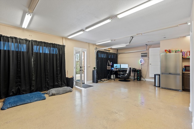 garage featuring stainless steel fridge and a wall mounted air conditioner