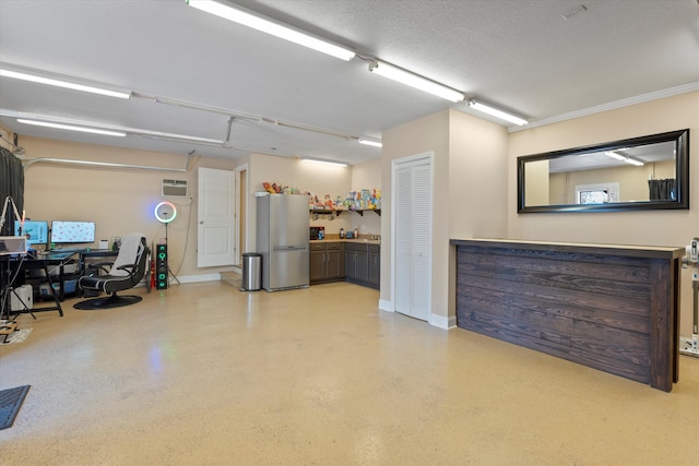 garage with stainless steel fridge and a wall mounted air conditioner