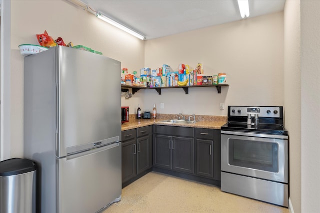 kitchen with light stone countertops, stainless steel appliances, and sink