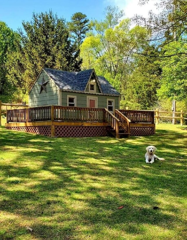 back of property with a deck and a lawn