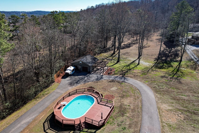 view of swimming pool with a wooden deck and an outbuilding