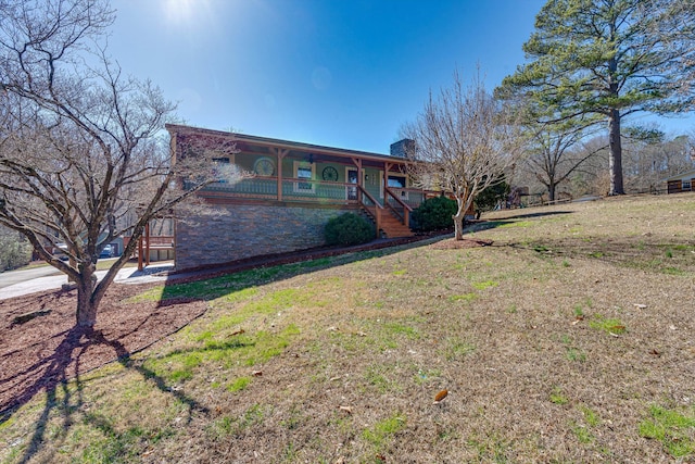 exterior space featuring covered porch and a front yard