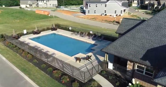 pool with a patio area and fence