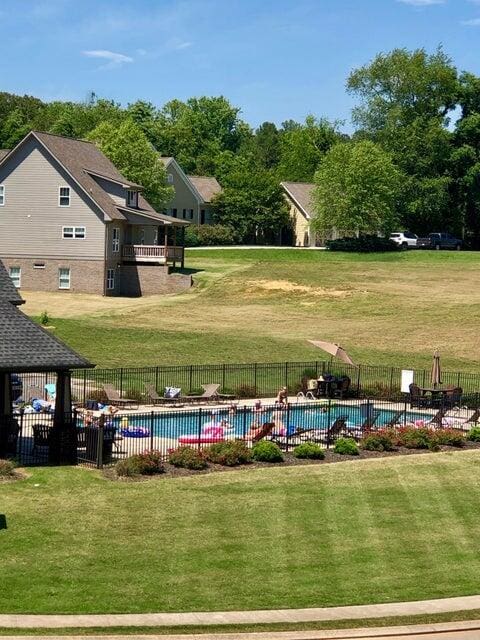 view of pool with a lawn