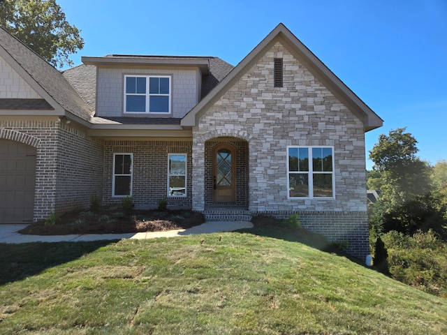 view of front of house featuring a garage and a front lawn