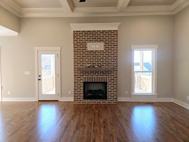 unfurnished living room with a fireplace, dark hardwood / wood-style flooring, beamed ceiling, and ornamental molding