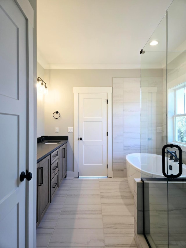 bathroom with a bath, vanity, tile patterned floors, and ornamental molding