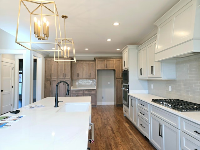 kitchen featuring appliances with stainless steel finishes, white cabinetry, pendant lighting, and sink