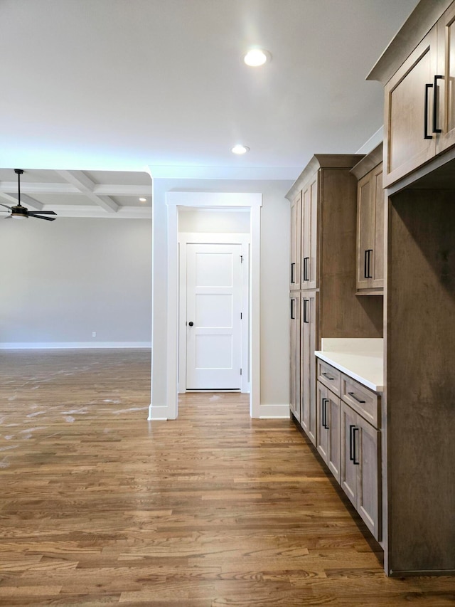 kitchen featuring ceiling fan, beam ceiling, dark hardwood / wood-style flooring, and coffered ceiling