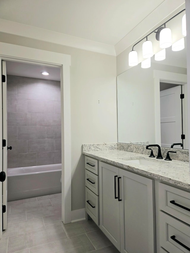 bathroom with tile patterned floors, vanity, and tiled shower / bath