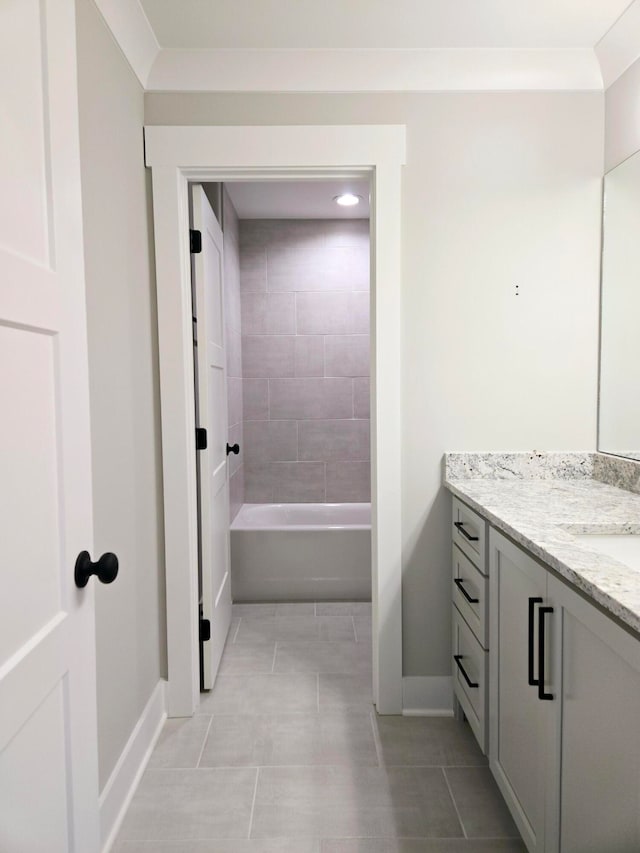 bathroom featuring tile patterned flooring, vanity, and tiled shower / bath combo