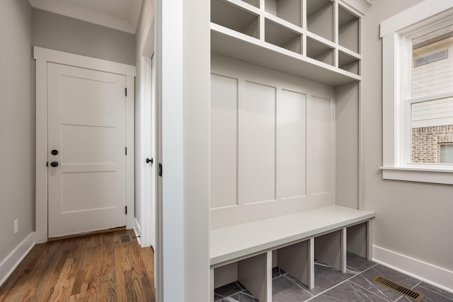 mudroom with visible vents, baseboards, and dark wood-type flooring