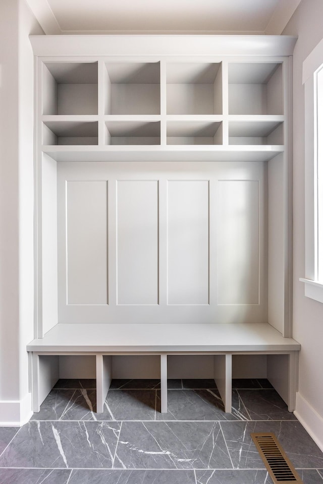 mudroom with visible vents, marble finish floor, and baseboards