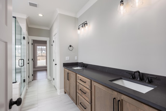 bathroom with crown molding, visible vents, a shower stall, and a sink