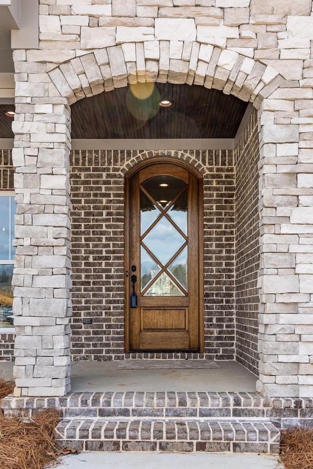 view of exterior entry featuring brick siding