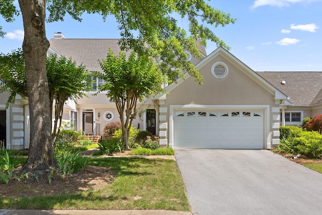 view of front of property with a chimney, stucco siding, an attached garage, and concrete driveway