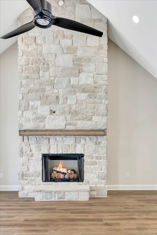 interior details featuring a fireplace, hardwood / wood-style flooring, and ceiling fan