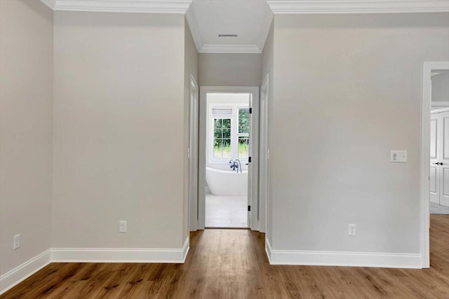 hallway with wood-type flooring and crown molding