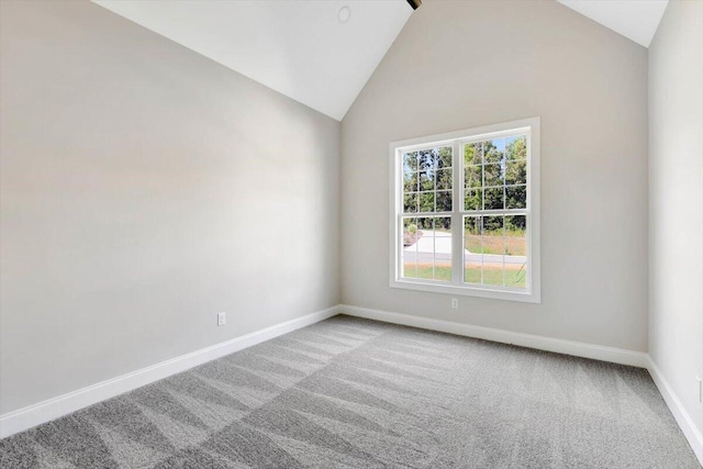 carpeted spare room featuring lofted ceiling