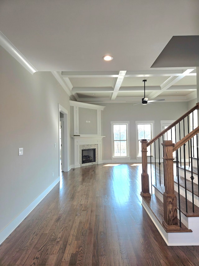 unfurnished living room with beamed ceiling, coffered ceiling, and dark hardwood / wood-style floors