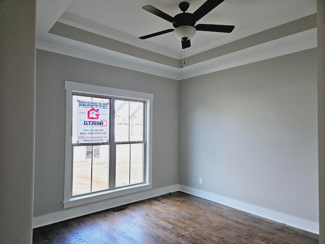 spare room with crown molding, ceiling fan, dark hardwood / wood-style floors, and a tray ceiling