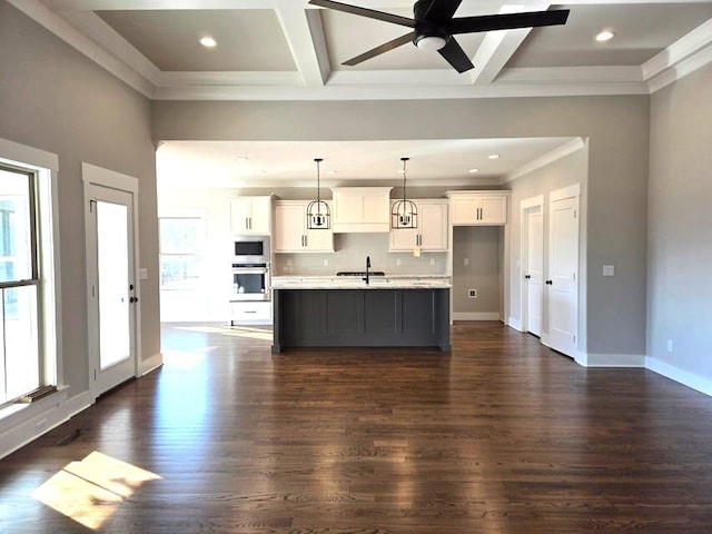 kitchen featuring white cabinetry, an island with sink, ceiling fan, dark wood-type flooring, and appliances with stainless steel finishes