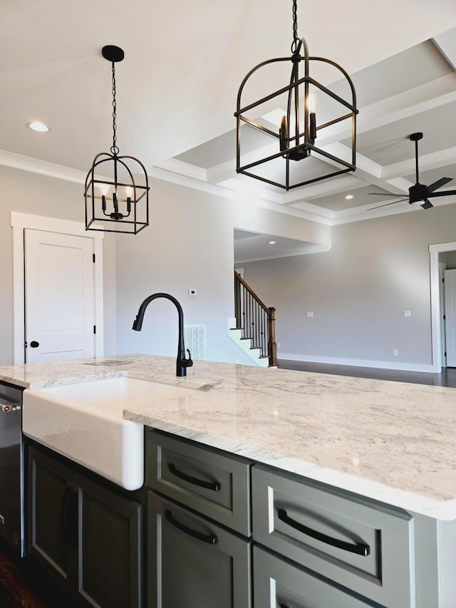 kitchen featuring crown molding, pendant lighting, ceiling fan with notable chandelier, and light stone countertops