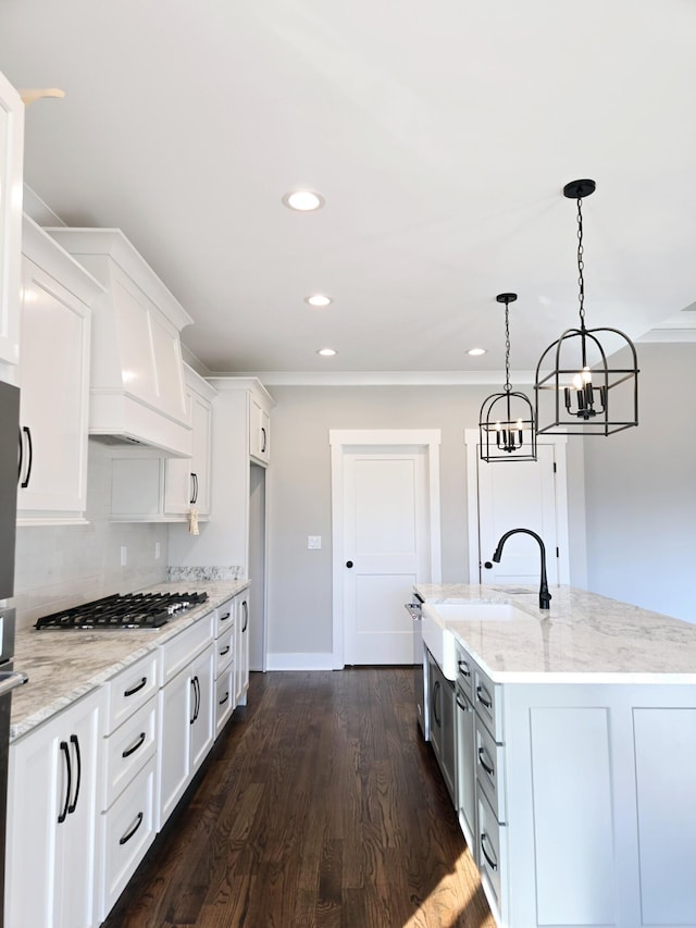 kitchen featuring a sink, dark wood finished floors, white cabinets, decorative backsplash, and stainless steel gas cooktop