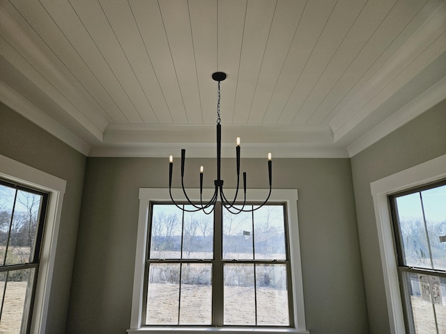 interior details with a tray ceiling, ornamental molding, and a chandelier