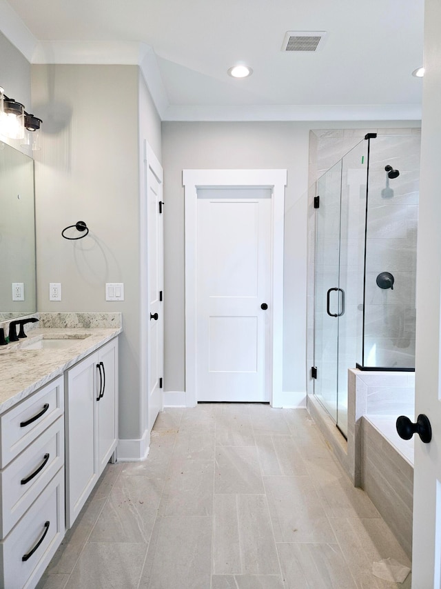 bathroom featuring ornamental molding, vanity, and separate shower and tub