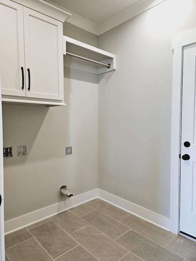 clothes washing area featuring tile patterned floors, cabinet space, baseboards, and washer hookup