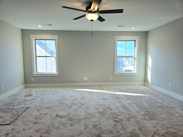 carpeted empty room featuring ceiling fan and plenty of natural light