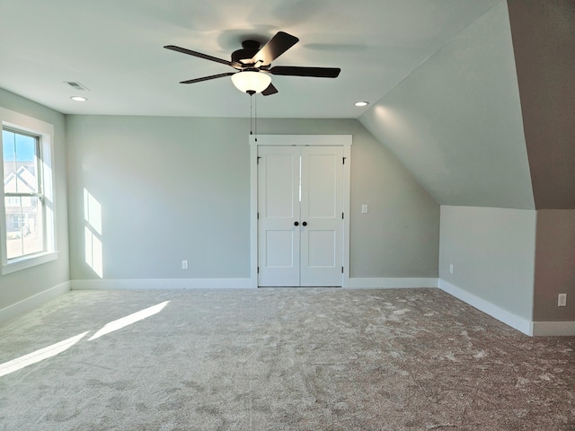 additional living space featuring lofted ceiling, carpet flooring, visible vents, and baseboards