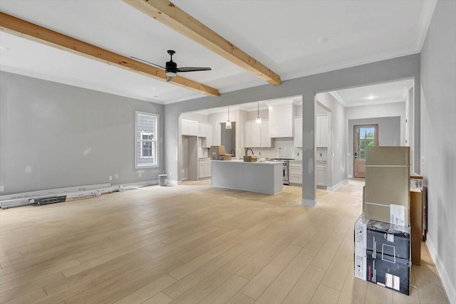 unfurnished living room with ceiling fan, light wood-type flooring, crown molding, and beam ceiling