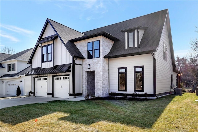 view of front of property featuring a garage, a front lawn, and central air condition unit