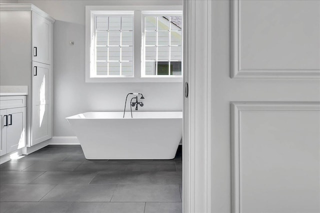 bathroom with vanity, a bath, and tile patterned flooring