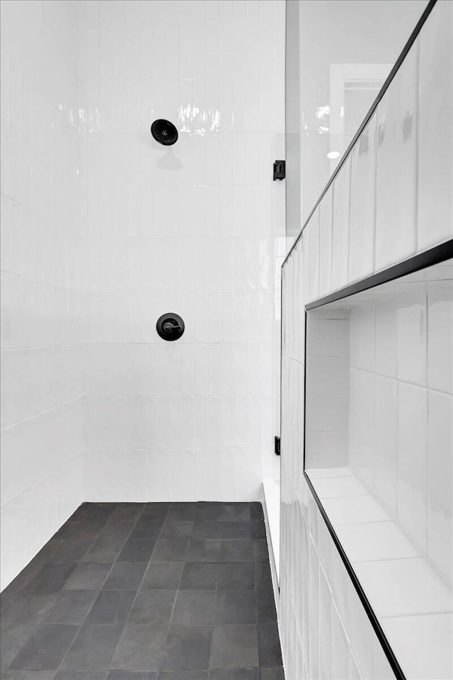 interior space with a tile shower and tile patterned floors