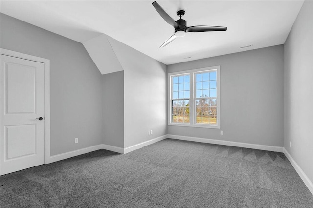 bonus room with ceiling fan and dark colored carpet