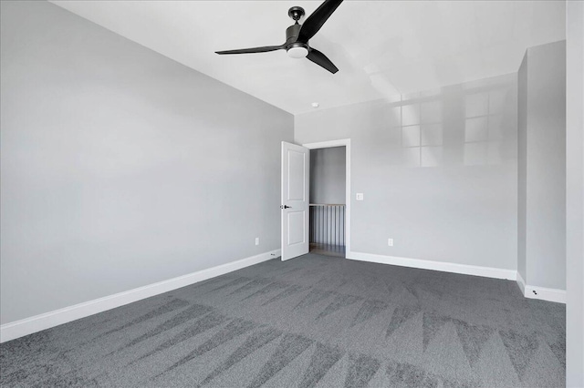 spare room with ceiling fan and dark colored carpet