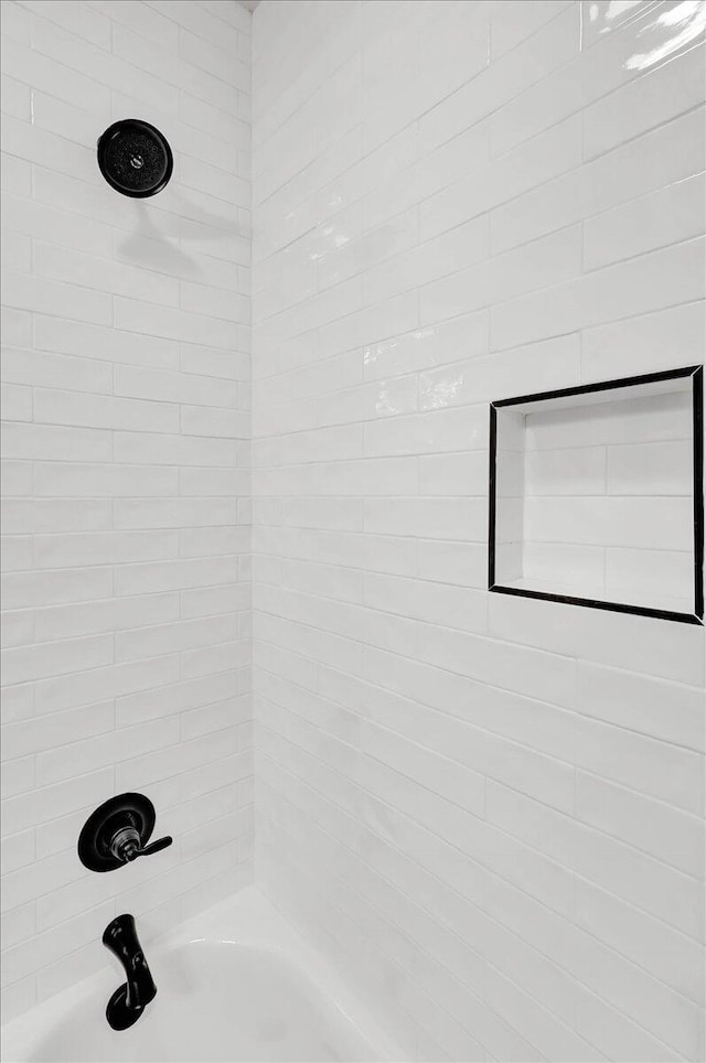 bathroom featuring tiled shower / bath