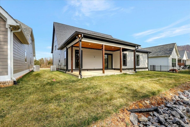 back of property featuring a patio, a yard, and central AC