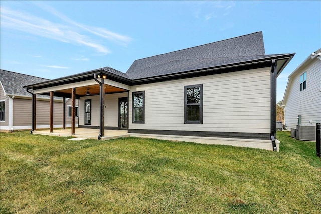 rear view of house with cooling unit, ceiling fan, a patio area, and a lawn