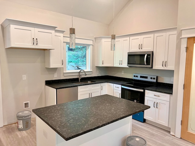 kitchen featuring white cabinetry, sink, stainless steel appliances, and decorative light fixtures