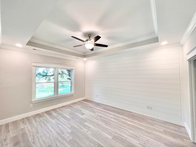 unfurnished room with ceiling fan, crown molding, light hardwood / wood-style flooring, and a tray ceiling