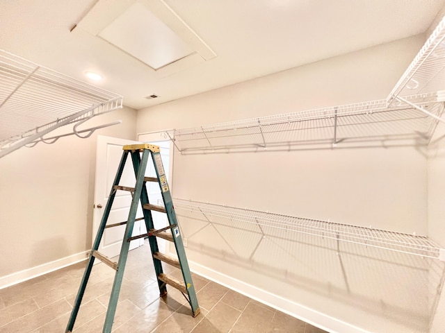 walk in closet featuring attic access