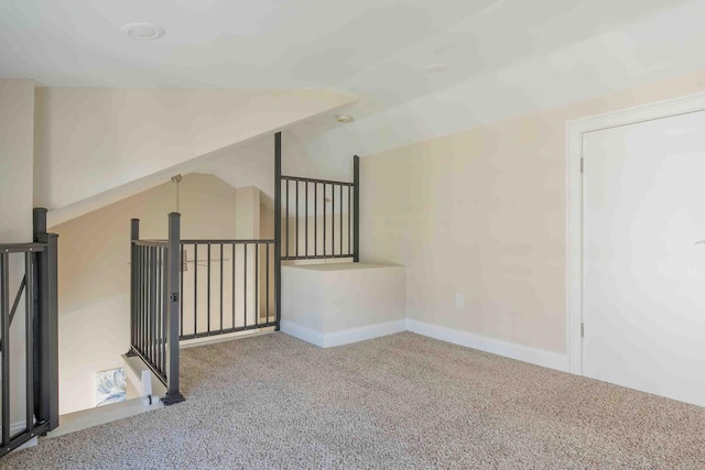 carpeted empty room featuring lofted ceiling