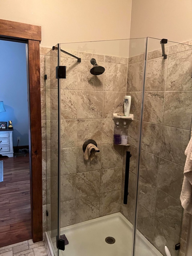 bathroom featuring wood-type flooring and an enclosed shower