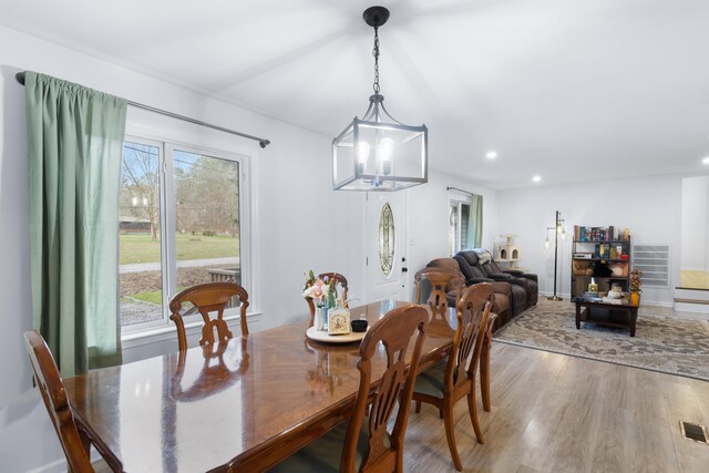 dining space with hardwood / wood-style floors and a chandelier